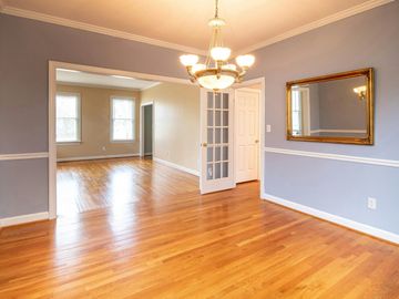 A large empty room with blue walls and  brown flooring.