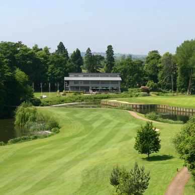 A golf course with the clubhouse and 18th island green.