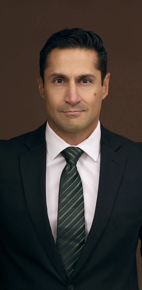 Stack of books next to pencils in a holder and a camera.