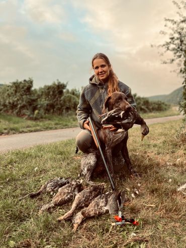 Young woman with hunting dog and hunted birds