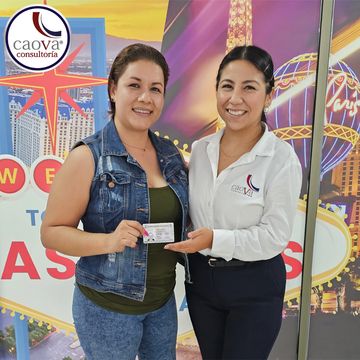 Asesor de migración y cliente sonriendo con visa de turista en mano. VISA B1/B2