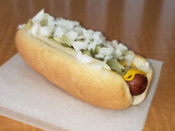 Little Cali Doggie all-beef hot dog, mustard, dill relish, diced onions on a table