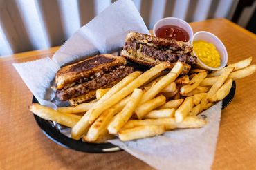 patty melt sandwich in basket with crispy baked fries
