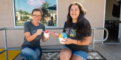 girls eating shave ice in on the patio bench