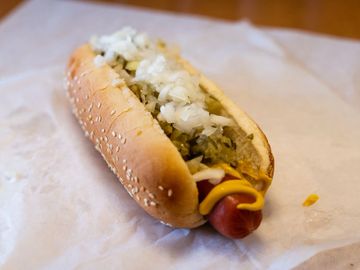 Cali Dog 1/4 lb all-beef hot dog on a sesame bun, yellow mustard, dill relish and diced onion