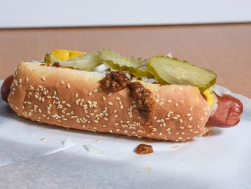 Chili Dog 1/4 lb all-beef hot dog on a sesame bun, yellow mustard, meat chili, diced onion, pickles