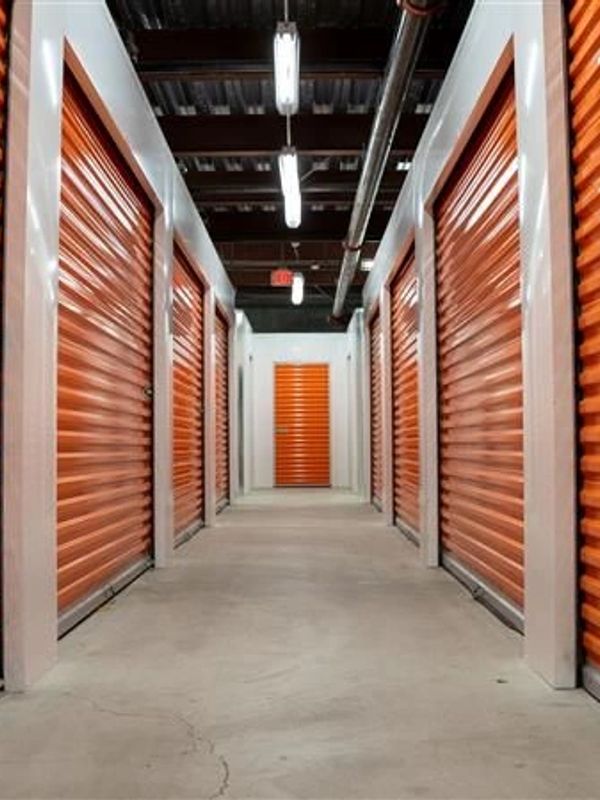 Indoor storage unit hallway with orange doors.