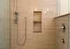 This shower features a linear drain, hand held shower fixtures, multiple height storage and barrier free access (safety grab bars not shown).