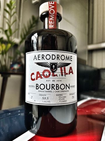 Bottle of Aerodrome Bourbon with a bold label and red text.