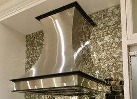 Stainless steel range hood with color matched trim, hand polished.