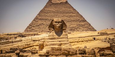 The Great Sphinx in front of a pyramid in Egypt.