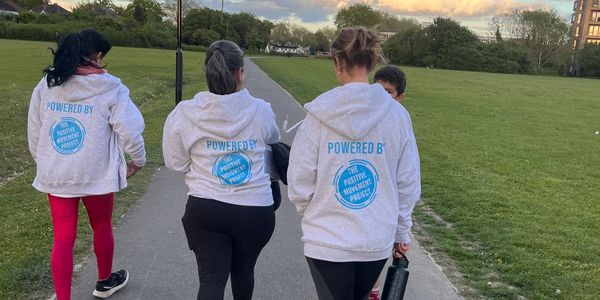 Group walking in matching hoodies with 'The Positive Movement Project' logo on the back.