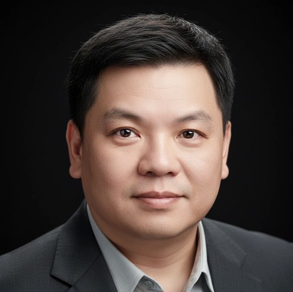 Professional headshot of a man in a suit against a black background.