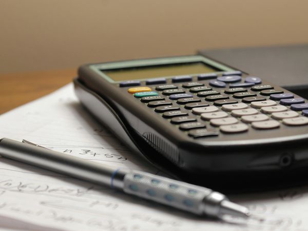 Scientific calculator and mechanical pencil on handwritten notes.