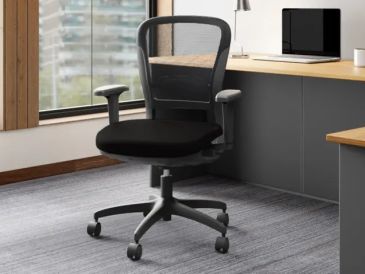 Black ergonomic office chair on wheels near desk.