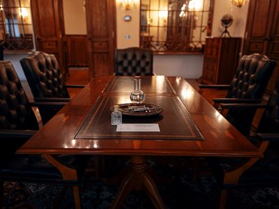 Elegant wooden conference table with leather chairs in a classic room.