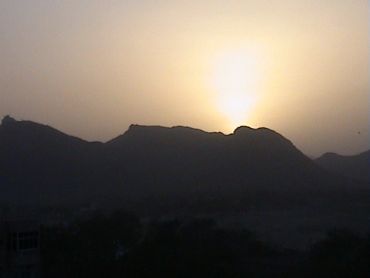 Sunset behind mountain silhouettes.
