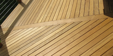 Close-up of custom wood deck with diagonal pattern and cable railing by Full Circle Building Group