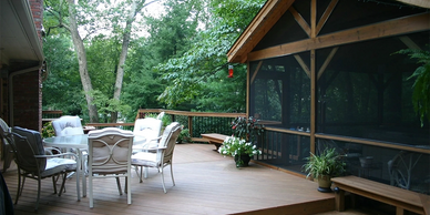 Spacious deck with dining area and attached screened-in 3-season room by Full Circle Building Group