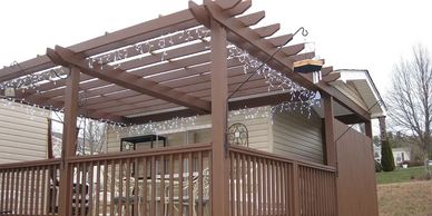 Custom wood deck with overhead pergola and string lights by Full Circle Building Group in WNC