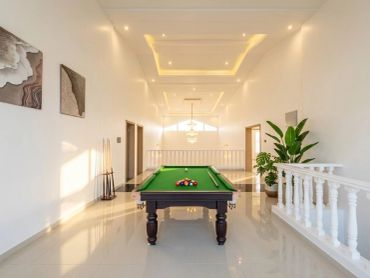 Bright room with a snooker table and plants.