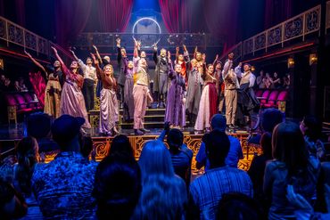 Theater cast takes a bow to an applauding audience after a performance.