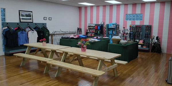 Indoor retail space with picnic tables and merchandise displays.