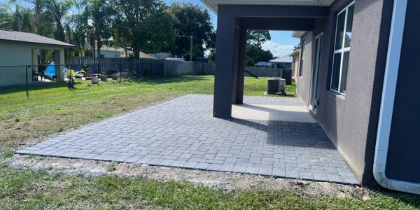 Newly installed gray stone patio next to house.