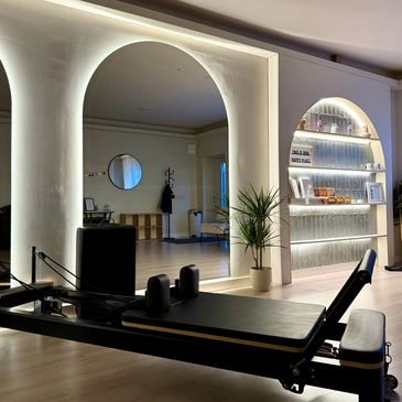 Modern Pilates studio with sleek reformer machine and ambient lighting.