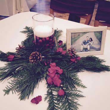 A photo frame with red rose petals and candles 
