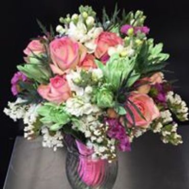 A bunch of pink and white flowers in a glass vase