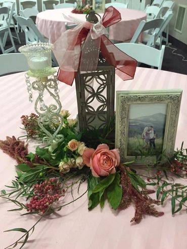 Pink roses with greenery and berries on table