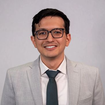 Young man in a suit smiling at the camera.