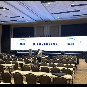Conference room with rows of chairs and a large welcome screen.