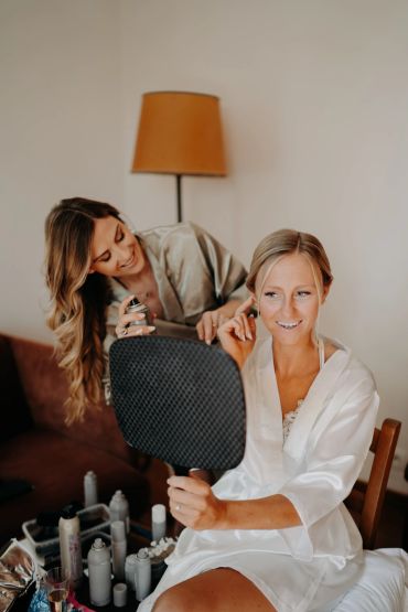 Femme assistant une mariée à se préparer.