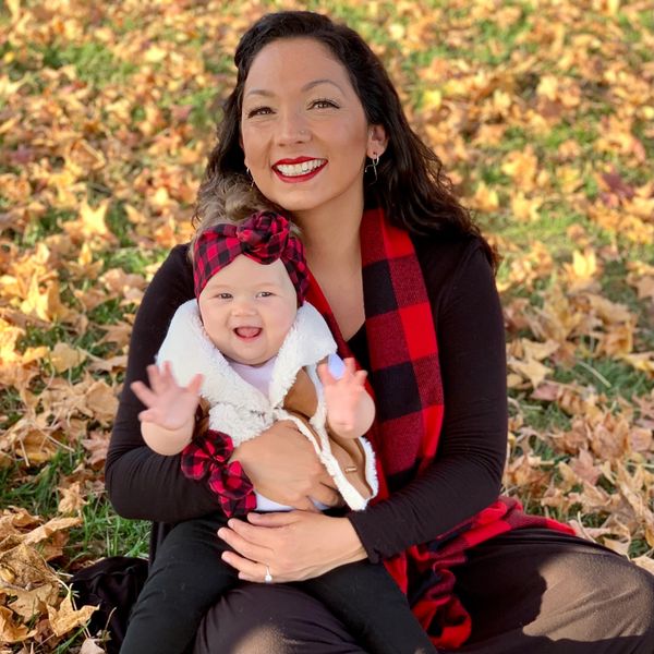 A joyful mother and baby enjoy a fall day surrounded by autumn leaves.