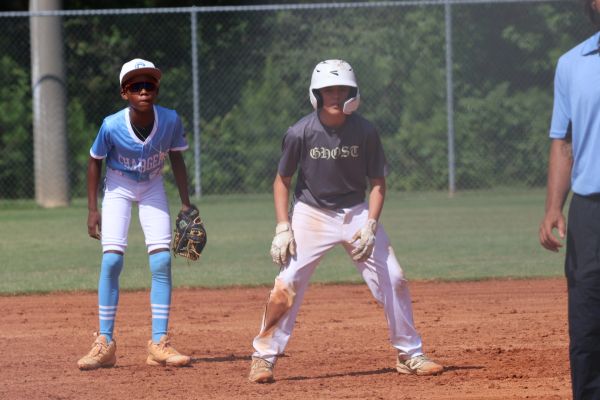 Two young baseball players ready on the field during a game.