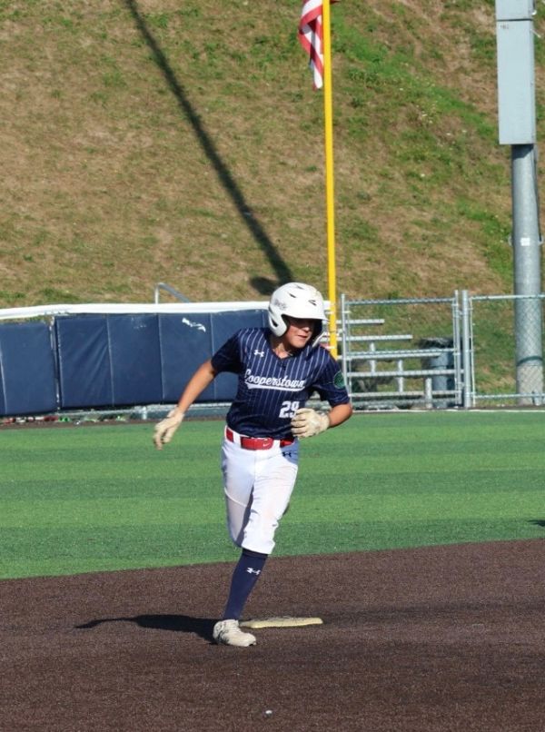 Baseball player running on the field, just touching base.
