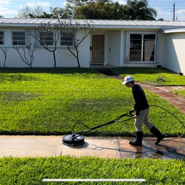 Man pressure cleaning a sidewalk 
