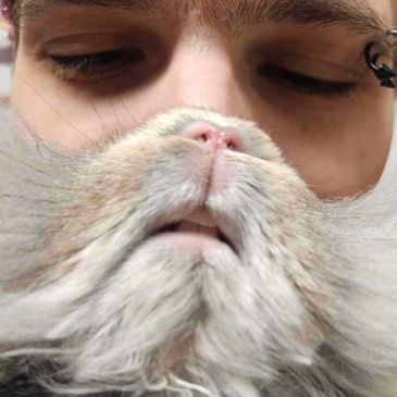 Person holding a fluffy cat close to their face.