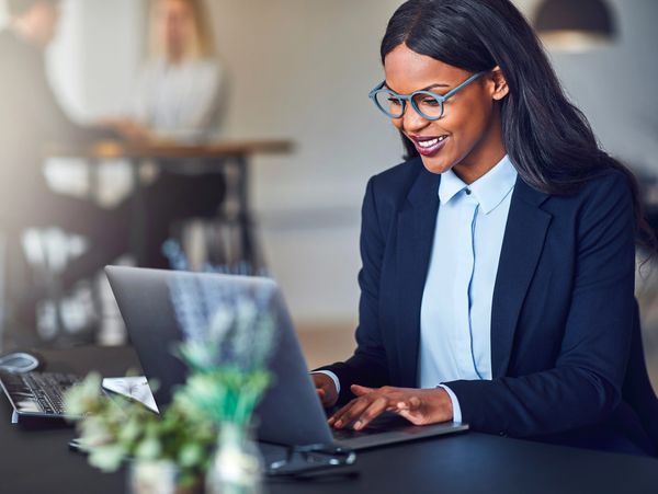 Smiling young African American businesswoman working on a laptop