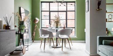 Modern dining area with green walls and natural light.