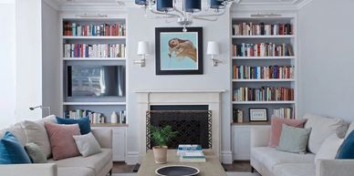 Cozy living room with symmetrical sofas, built-in bookshelves, and a fireplace.