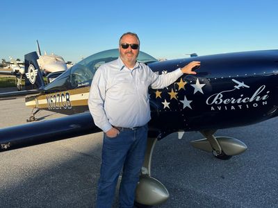 Criminal Defense Attorney Sean Clayton standing in front of an Extra 300 in which he's just done spi