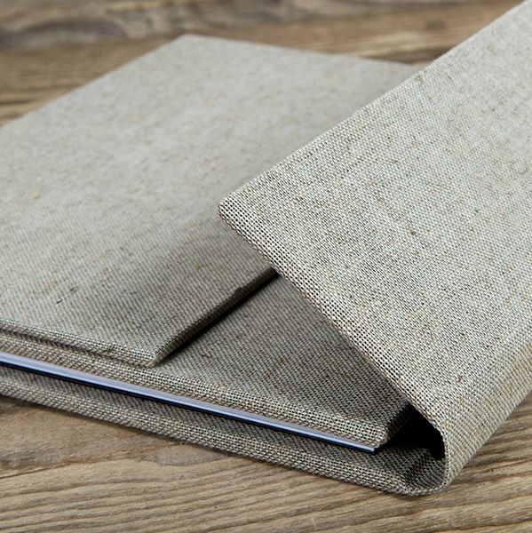 Close-up of a beige fabric notebook cover on a wooden surface.