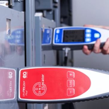 Hand-held coating thickness gauge measuring metal surface thickness.