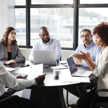 Diverse professionals engaged in a business meeting around a conference table.