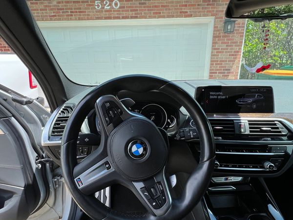 Interior view of a BMW car with a visible steering wheel and dashboard.