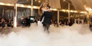 Newlyweds share a magical first dance surrounded by low fog and twinkling lights.