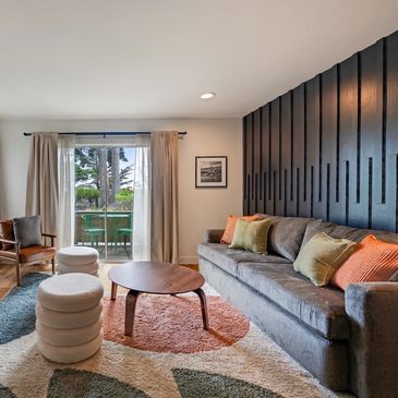 Modern living room with gray sofa and artistic wall panel.